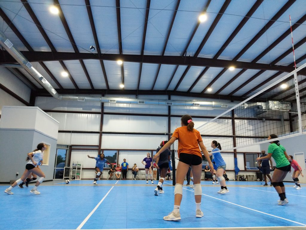 Girls playing volleyball at training facility